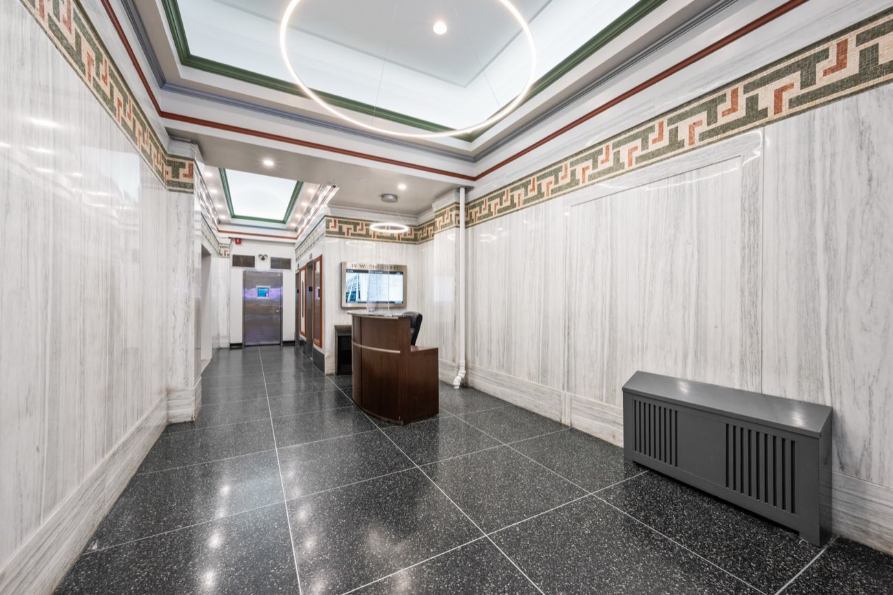 Renovated lobby with marble walls, mosaic frieze and terrazzo floor