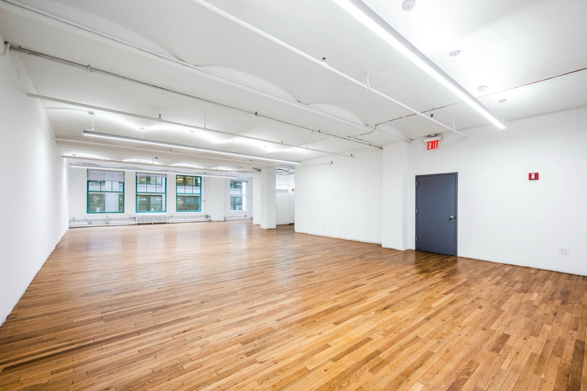 Wide open loft floor with a run of windows